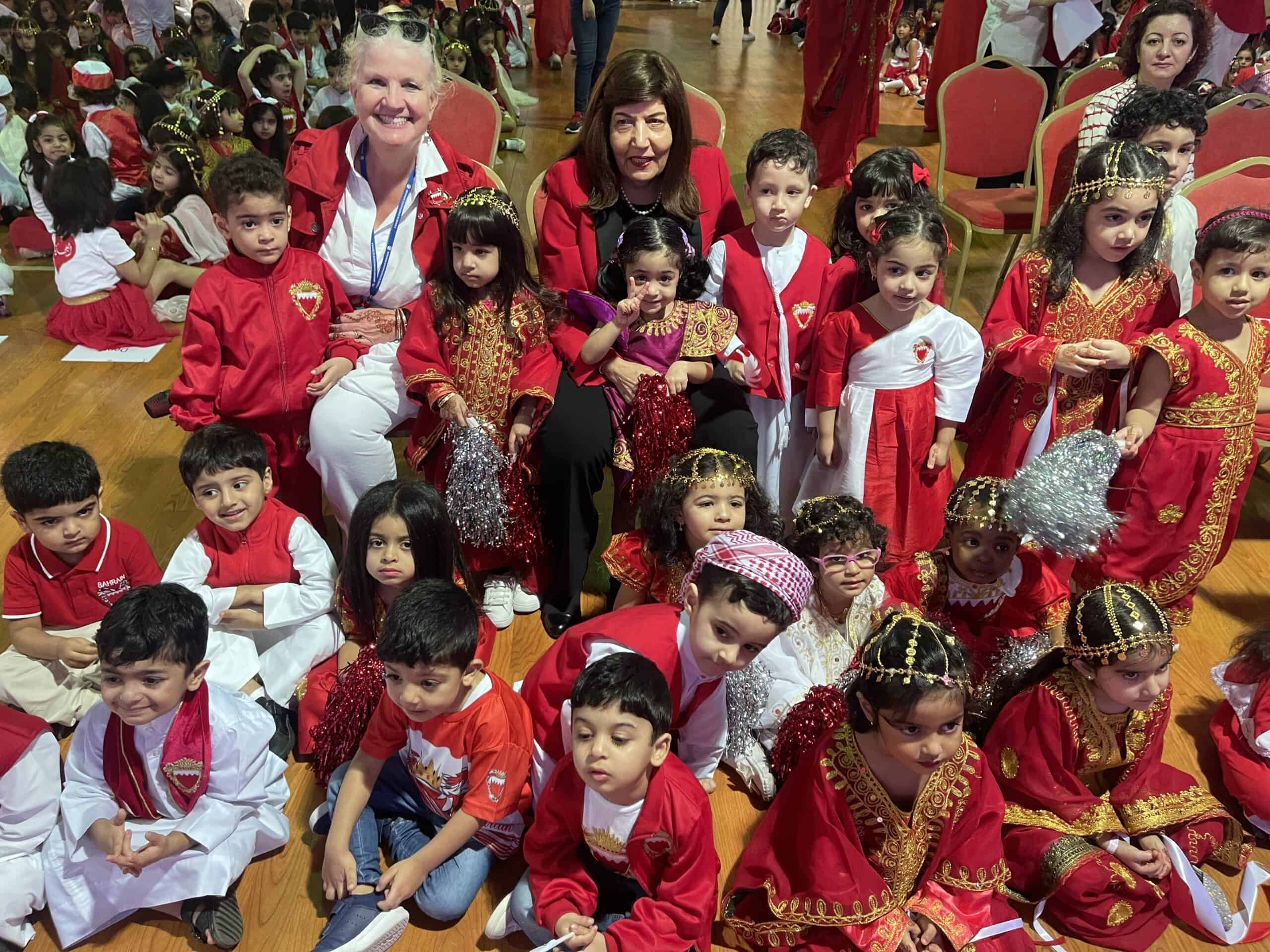 Colorful group of young children and teachers celebrating a cultural event at MKS School in Bahrain, dressed in traditional and festive costumes, highlighting diversity, cultural pride, and school community spirit.